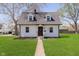Charming two-story home featuring a manicured lawn, light siding, and a welcoming pathway to the front door at 402 N 19Th Ave, Beech Grove, IN 46107