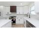 Stylish kitchen featuring stainless steel appliances, white cabinets, quartz countertops, and a farm sink at 402 N 19Th Ave, Beech Grove, IN 46107