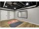 Basement gym featuring workout mats, mirror, open ceiling, and three storage closets at 4339 Royal Pine Blvd, Indianapolis, IN 46250