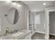 Bathroom featuring a marble vanity, round mirror, shower, and window, providing natural light at 4339 Royal Pine Blvd, Indianapolis, IN 46250