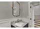 Elegant powder room boasts marble countertops, gold fixtures, and classic wainscoting for a refined touch at 4339 Royal Pine Blvd, Indianapolis, IN 46250