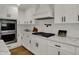 Close-up of the kitchen featuring white cabinets, countertops, subway tile, and stainless steel appliances at 4339 Royal Pine Blvd, Indianapolis, IN 46250