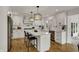 Bright kitchen with white cabinetry, stainless steel appliances, large island, and hardwood floors at 4339 Royal Pine Blvd, Indianapolis, IN 46250