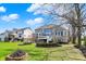 View of the backyard with a stone fire pit, lush lawn, and mature trees at 4410 Miller Way, Westfield, IN 46062