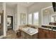 Elegant bathroom featuring a soaking tub, dual vanity, tile floors, and a view to the walk-in closet at 4410 Miller Way, Westfield, IN 46062