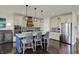 Modern kitchen with stainless steel appliances, a blue island with a white countertop, and dark hardwood floors at 4410 Miller Way, Westfield, IN 46062