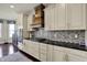 Charming kitchen featuring white cabinets, a black countertop, tile backsplash, and a wooden range hood at 4410 Miller Way, Westfield, IN 46062