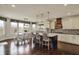 Open-concept kitchen with an island, chairs, pendant lighting, a breakfast table, and dark hardwood floors at 4410 Miller Way, Westfield, IN 46062