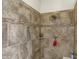 Tile shower featuring stone accents, updated fixtures, and a convenient corner shelf for toiletries at 4410 Miller Way, Westfield, IN 46062