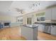 Open kitchen flowing into a living area, featuring an island, stainless steel appliances and hardwood floors at 45 Wisteria Way, Westfield, IN 46074