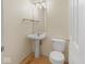 Small powder room with a pedestal sink, toilet, and modern lighting fixture at 45 Wisteria Way, Westfield, IN 46074