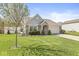 Charming single-story home featuring brick accents, vinyl siding, landscaped front yard, and a two-car garage at 47 Thornburg Pkwy, Brownsburg, IN 46112