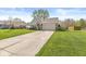 Single-story home with well-manicured lawn, mature trees, and a long driveway leading to an attached garage at 47 Thornburg Pkwy, Brownsburg, IN 46112