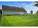 Spacious backyard featuring a well-maintained lawn, chainlink fence and rear door at 4786 N Mill Ct, Greenfield, IN 46140
