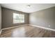 Bedroom with light grey walls, window with blinds, and wood-look laminate flooring at 4786 N Mill Ct, Greenfield, IN 46140