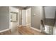 Hallway leading to bathroom, bedroom and stairs, featuring light grey walls and wood-look floor at 4786 N Mill Ct, Greenfield, IN 46140
