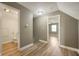 Hallway with open doorway to bedroom and bathroom, featuring light grey walls and wood-look floor at 4786 N Mill Ct, Greenfield, IN 46140