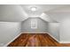 Attic space with hardwood floors, white walls, and a small window at 507 Dr Martin Luther King Jr Blvd, Anderson, IN 46016