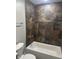 Bathroom features a tiled wall, modern fixtures, and tub at 517 W 26Th St, Indianapolis, IN 46208