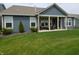 Blue home's backyard featuring a covered patio, lush green lawn, and manicured landscaping at 5269 Parkhurst Xing, McCordsville, IN 46055