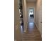Hallway with wood flooring leading to a well-lit bedroom; neutral decor at 5269 Parkhurst Xing, McCordsville, IN 46055