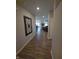 Hallway with wood flooring leading to a bright living area; decorative wall art at 5269 Parkhurst Xing, McCordsville, IN 46055