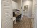 Hallway office nook features built-in desk and cabinetry, with a view to the laundry room at 5269 Parkhurst Xing, McCordsville, IN 46055