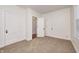 A bright bedroom with carpet, featuring two interior doors and a window that offers natural light at 548 E 39Th St, Indianapolis, IN 46205