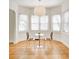 Sunlit dining area with hardwood floors, a pendant light, and a bay window with blinds at 548 E 39Th St, Indianapolis, IN 46205