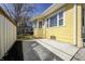 View of the home's yellow stucco exterior and concrete patio at 548 E 39Th St, Indianapolis, IN 46205