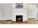 Close-up of a classic white fireplace with logs inside and a picture hanging above it at 548 E 39Th St, Indianapolis, IN 46205