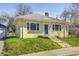 View of the home with a blue front door, neat landscaping, and well-maintained lawn at 548 E 39Th St, Indianapolis, IN 46205