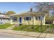 Charming yellow home with a blue front door, a landscaped lawn, and concrete steps leading to the entrance at 548 E 39Th St, Indianapolis, IN 46205