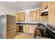 Kitchen featuring stainless steel appliances, wooden cabinets, and dark countertops at 548 E 39Th St, Indianapolis, IN 46205