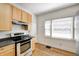 Kitchen features stainless steel appliances, wooden cabinets, and light countertops at 548 E 39Th St, Indianapolis, IN 46205