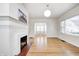 Bright and airy living room with hardwood floors, a fireplace, and arched doorway to dining area at 548 E 39Th St, Indianapolis, IN 46205