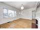 Sunlit living room with hardwood floors, a large window, a fireplace, and white walls at 548 E 39Th St, Indianapolis, IN 46205