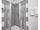 A shower stall features gray tile and silver trim, with a white corner base and hardware, complemented by white walls at 548 E 39Th St, Indianapolis, IN 46205