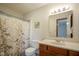 Neat bathroom featuring a vanity, toilet, shower with a bird-themed curtain and decor at 5555 W Vermont St, Indianapolis, IN 46224