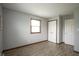 Simple bedroom with wood-look floors, white closet doors, and natural light at 5555 W Vermont St, Indianapolis, IN 46224