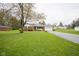 Brick ranch home with a long driveway, well-manicured lawn, and mature trees at 5555 W Vermont St, Indianapolis, IN 46224