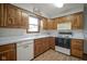Efficient kitchen with white appliances, wood cabinets, and ample counter space at 5555 W Vermont St, Indianapolis, IN 46224