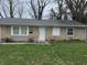 Single story home featuring tan siding, a gray shingled roof, and a well-maintained lawn at 5858 E 44Th St, Indianapolis, IN 46226