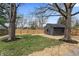Scenic backyard featuring a large yard, new fence, an outbuilding, mature trees, and fresh mulch at 5954 Crestview Ave, Indianapolis, IN 46220