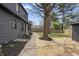 A view of the landscaped backyard with mulch and flower beds, green grass and trees, and a sidewalk at 5954 Crestview Ave, Indianapolis, IN 46220