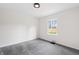 This bedroom features a ceiling light, grey carpet, one window with natural light, and white walls at 5954 Crestview Ave, Indianapolis, IN 46220