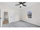 This bedroom features a ceiling fan, grey carpet, one window, and a white door at 5954 Crestview Ave, Indianapolis, IN 46220