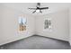 This bedroom features a ceiling fan, grey carpet, two windows with natural light, and white walls at 5954 Crestview Ave, Indianapolis, IN 46220
