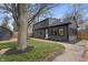 Side view of a stylish two-story house featuring dark siding, black framed windows, and beautifully landscaped flowerbeds at 5954 Crestview Ave, Indianapolis, IN 46220