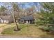 Eye-level aerial view of the home, showcasing its dark exterior, lush landscaping, and charming curb appeal at 5954 Crestview Ave, Indianapolis, IN 46220